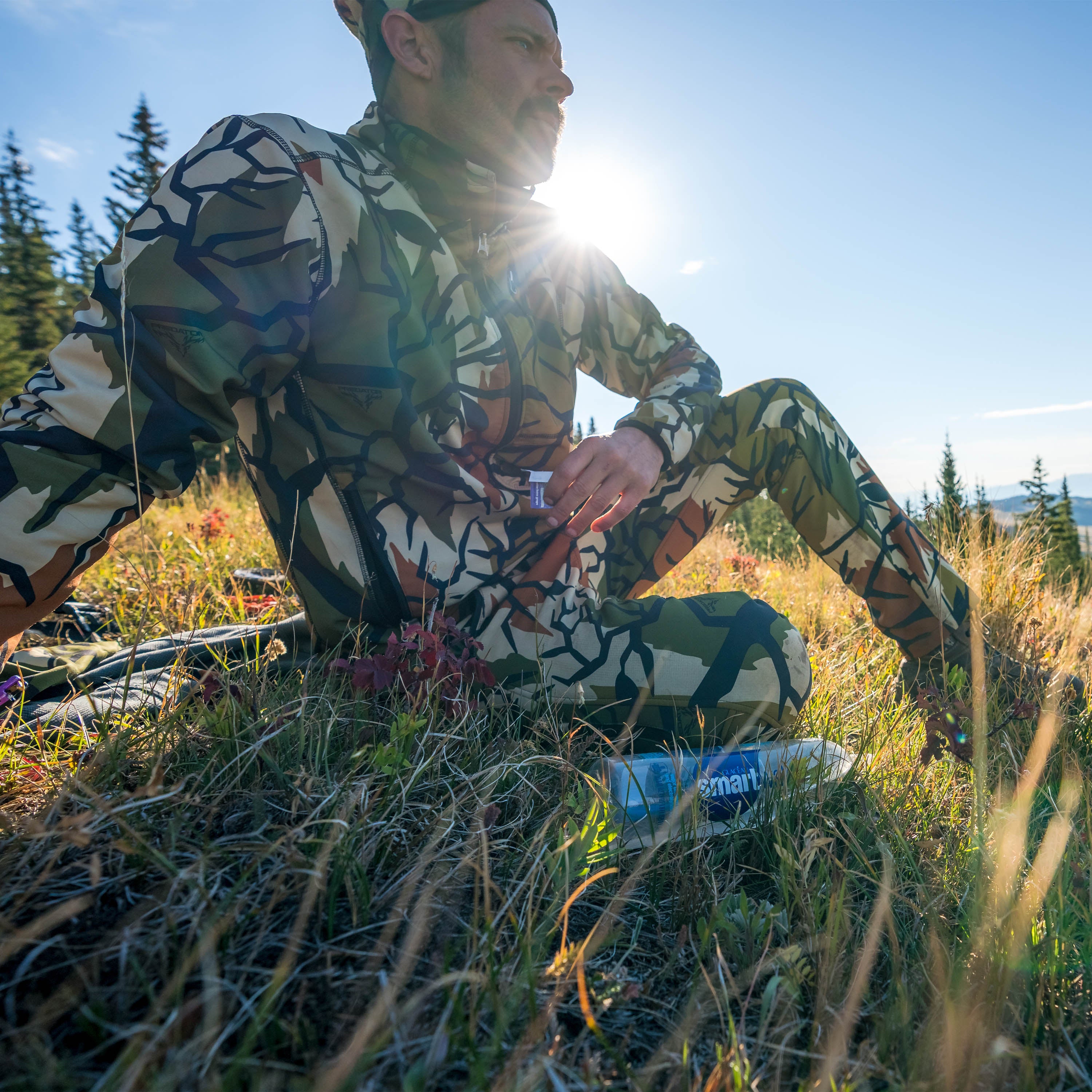 spring gereen camo on hillside with a water